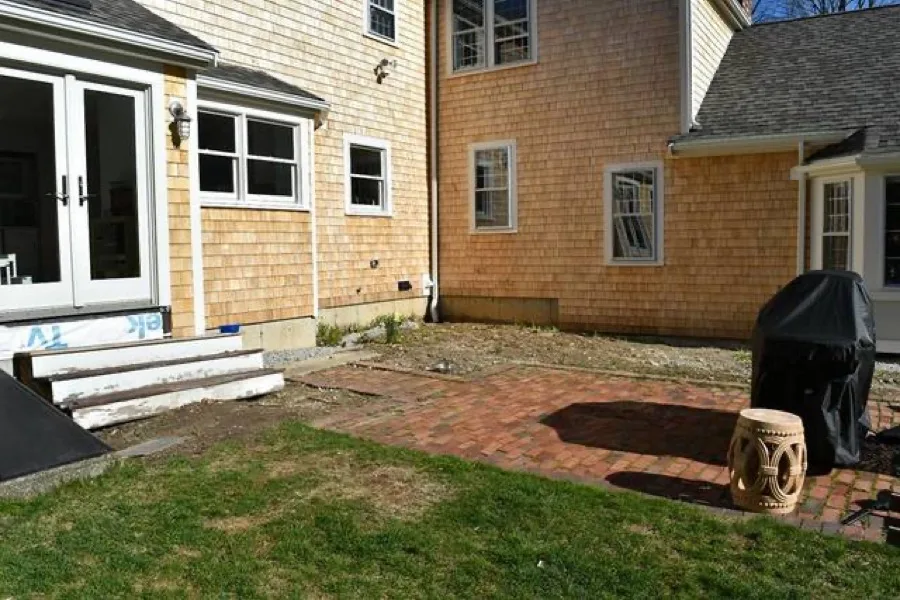 A colonial-style South Shore home with a manicured lawn and granite entry steps maintained by Global Green Lawncare