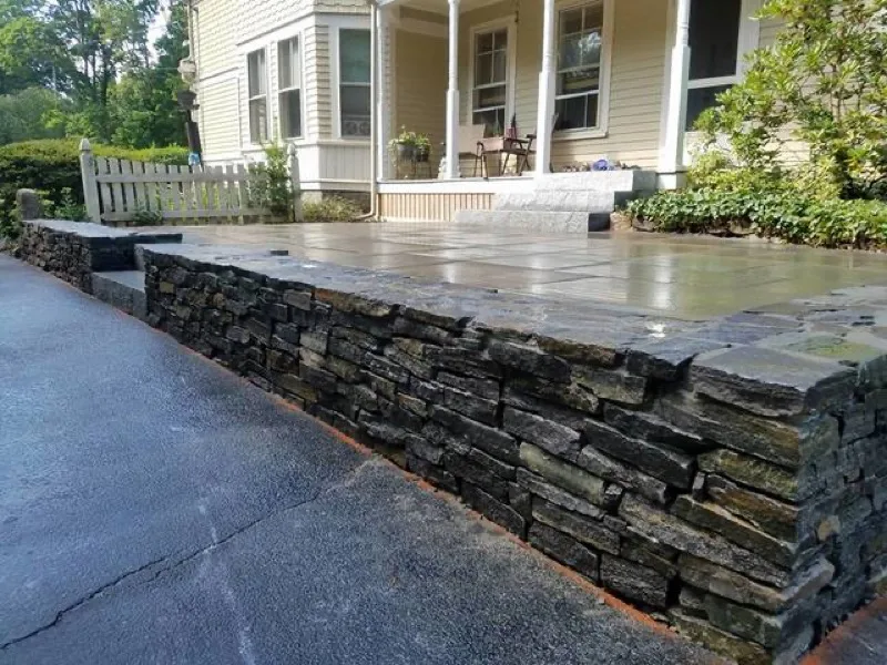 Stacked stone retaining wall with bluestone patio steps